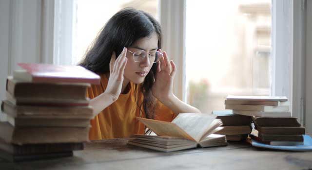 female-student-suffering-from-headache-in-library-3808057