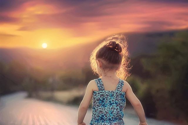 little girl walking during sunset